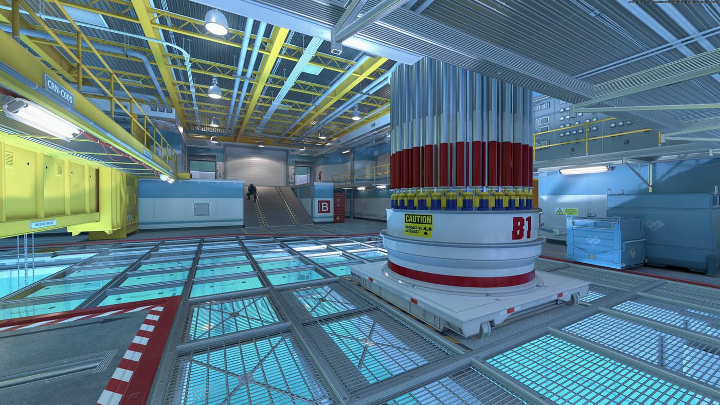 A brightly lit industrial interior in Counter-Strike 2 with a bomb site marked B1 on a red-and-white cylindrical container, glass floor panels and overhead gantries — a defusal site on a map that looks nothing like the Active Duty maps